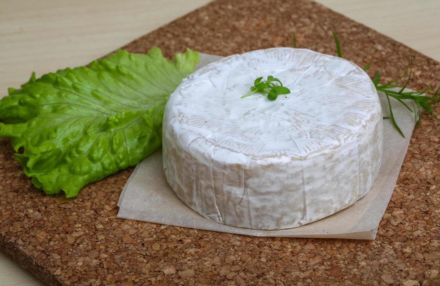 Camembert cheese on wooden board and wooden background photo