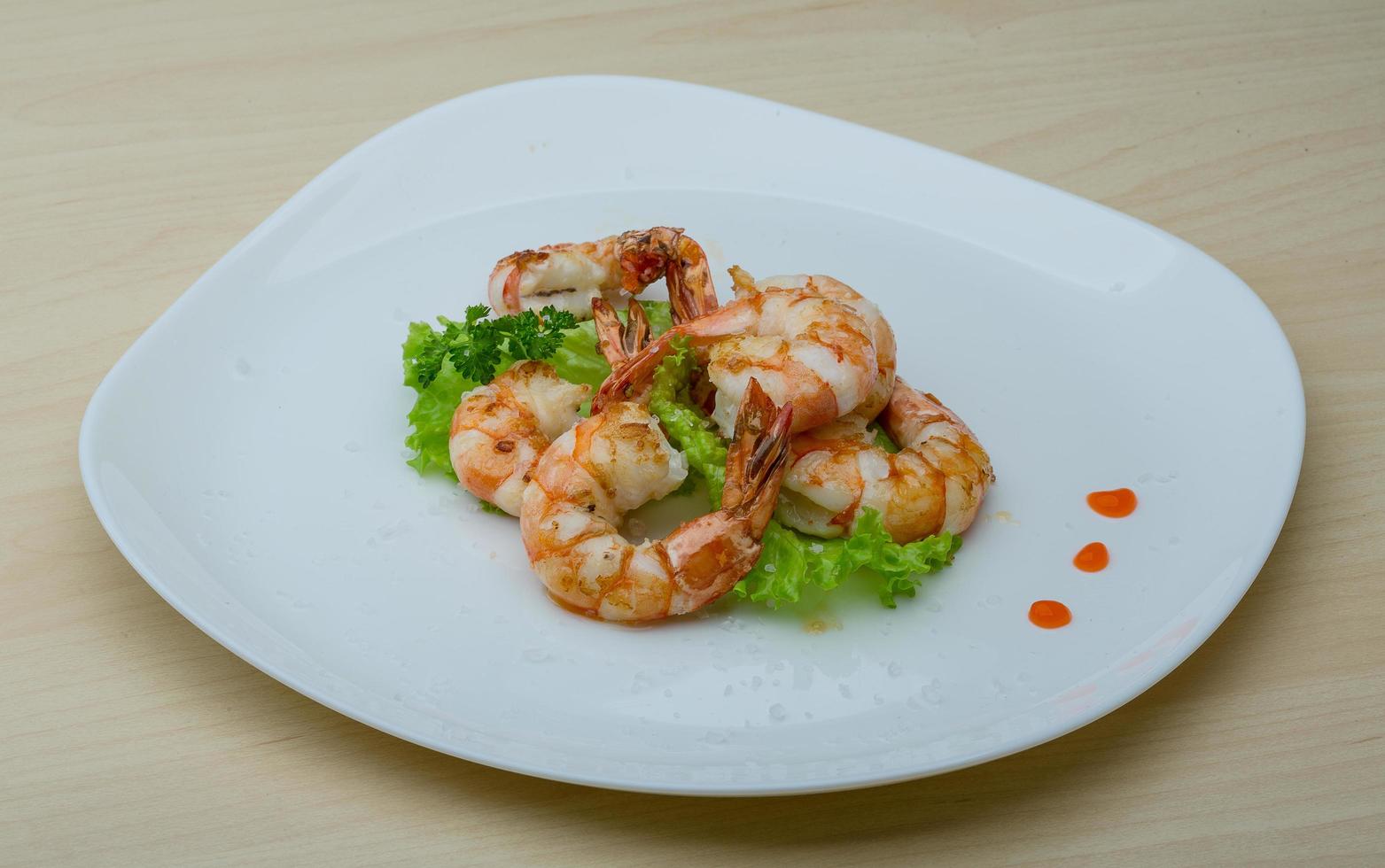 Tiger shrimps on the plate and wooden background photo