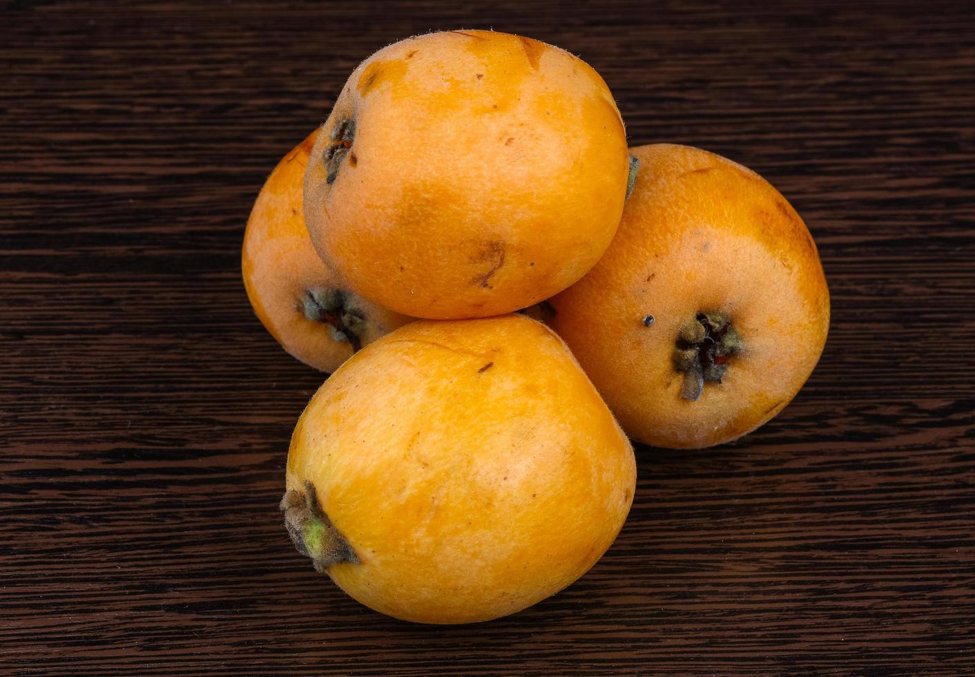Medlar on wooden background photo