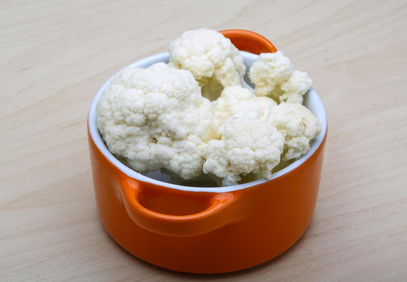 Cauliflower in a bowl on wooden background photo