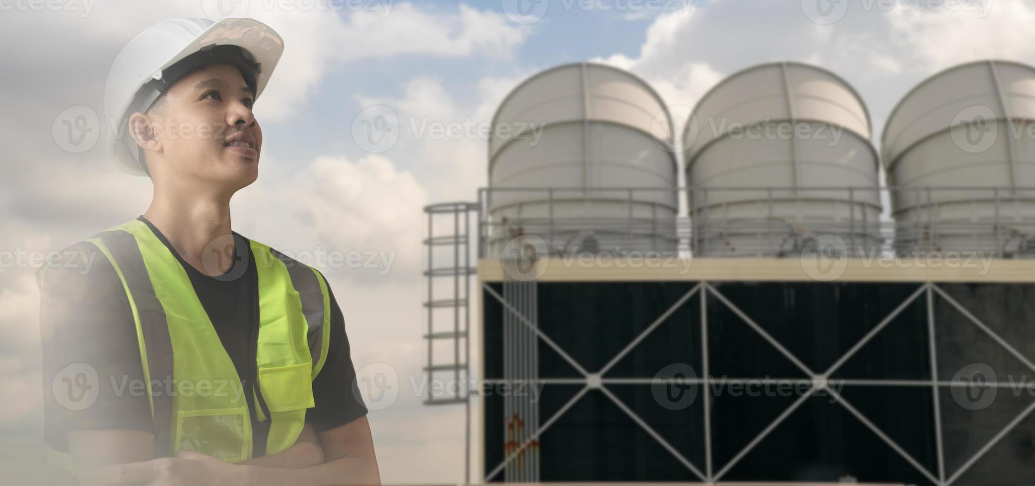 Double exposure image of Mechanical engineer with cooling tower on office building,Asian engineer looking forward to success work,young adult wearing white helmet and suit safety,banner concept. photo