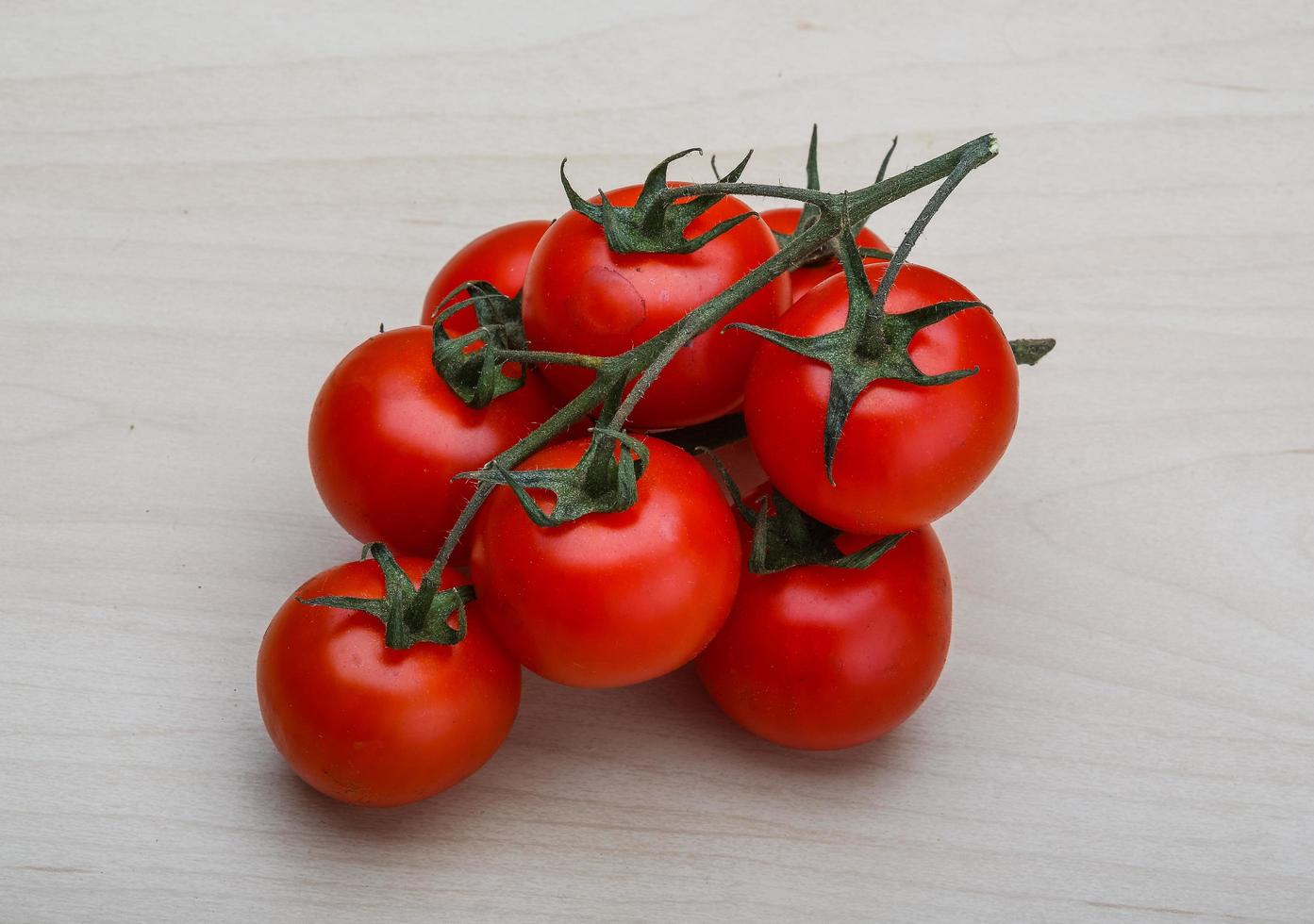 Tomato branch on wooden background photo