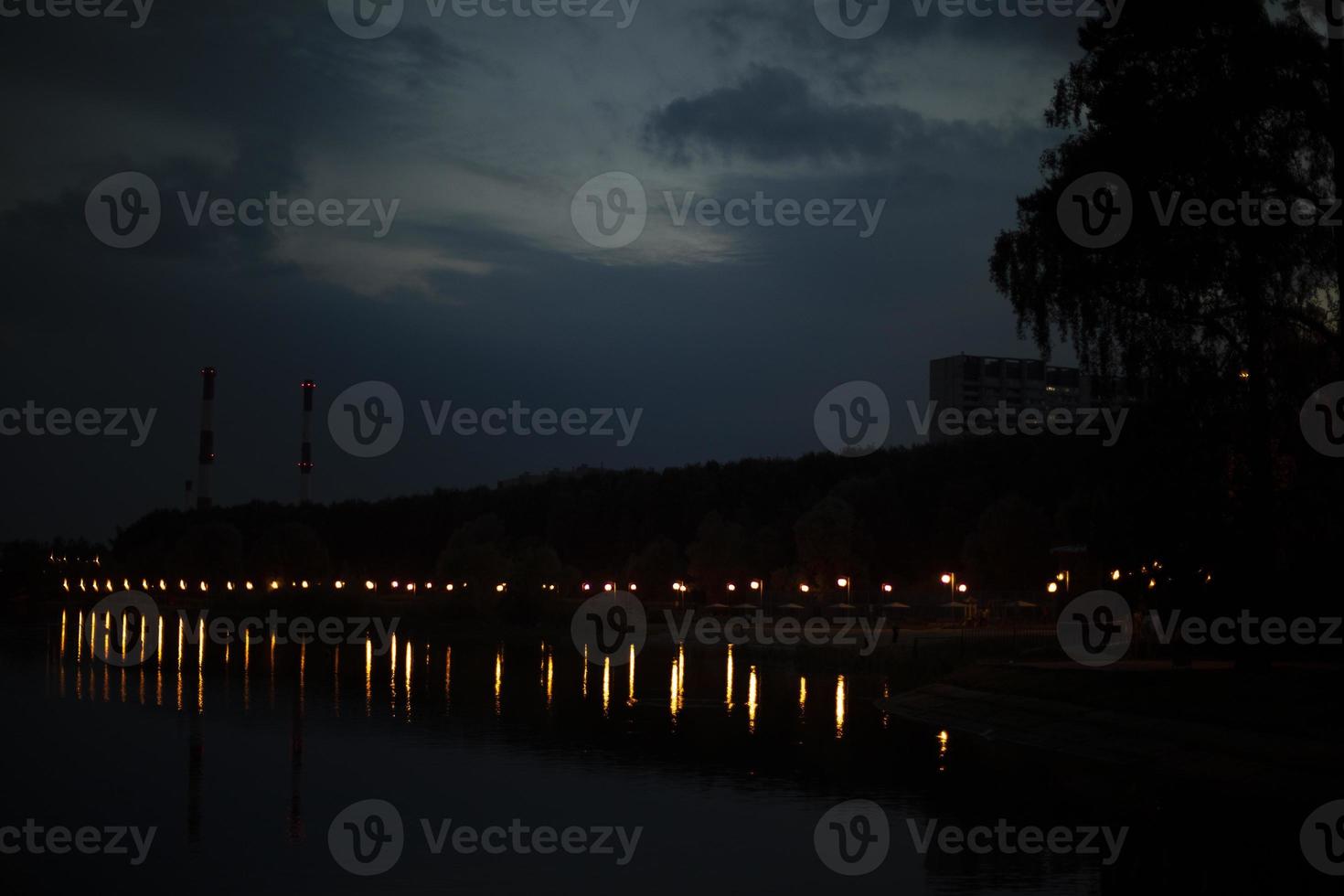 luces en el paseo marítimo. lago por la noche en el parque. foto