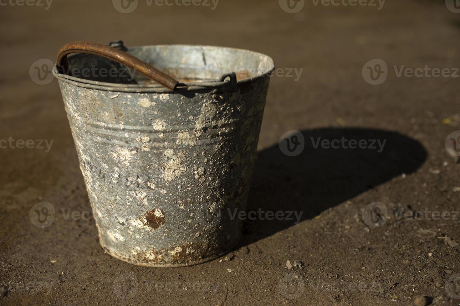 Old bucket of metal. Rusty bucket covered with lichen. Old item. photo