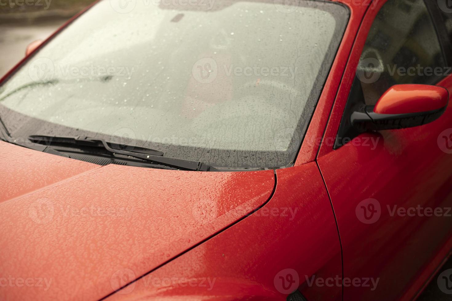 Red car. Wet car in parking lot. photo