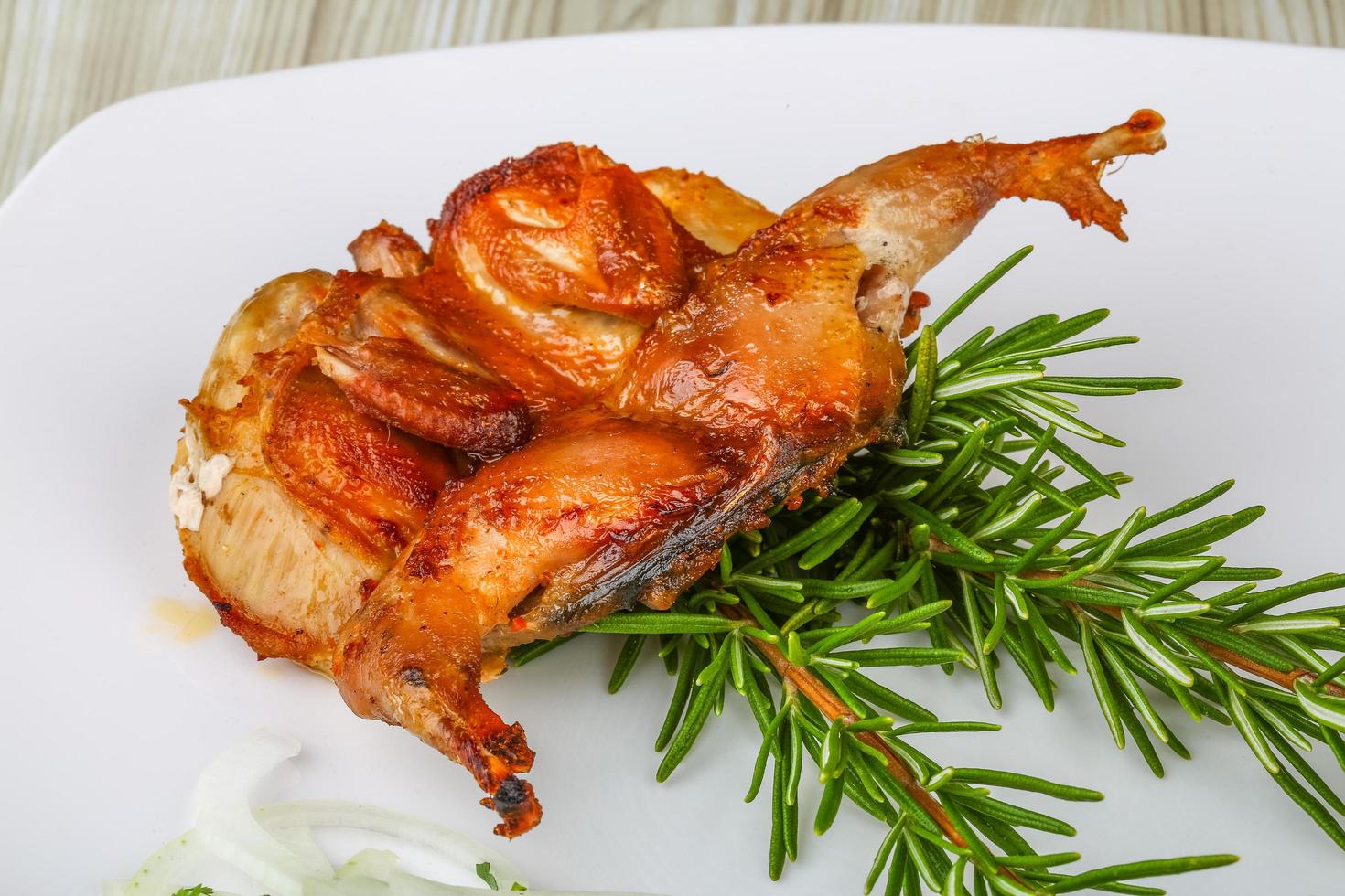 Grilled quail on the plate and wooden background photo