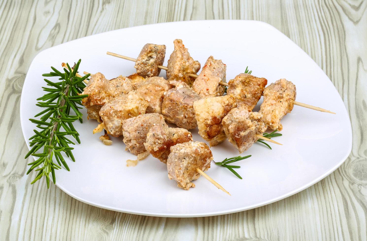 Chicken skewer on the plate and wooden background photo
