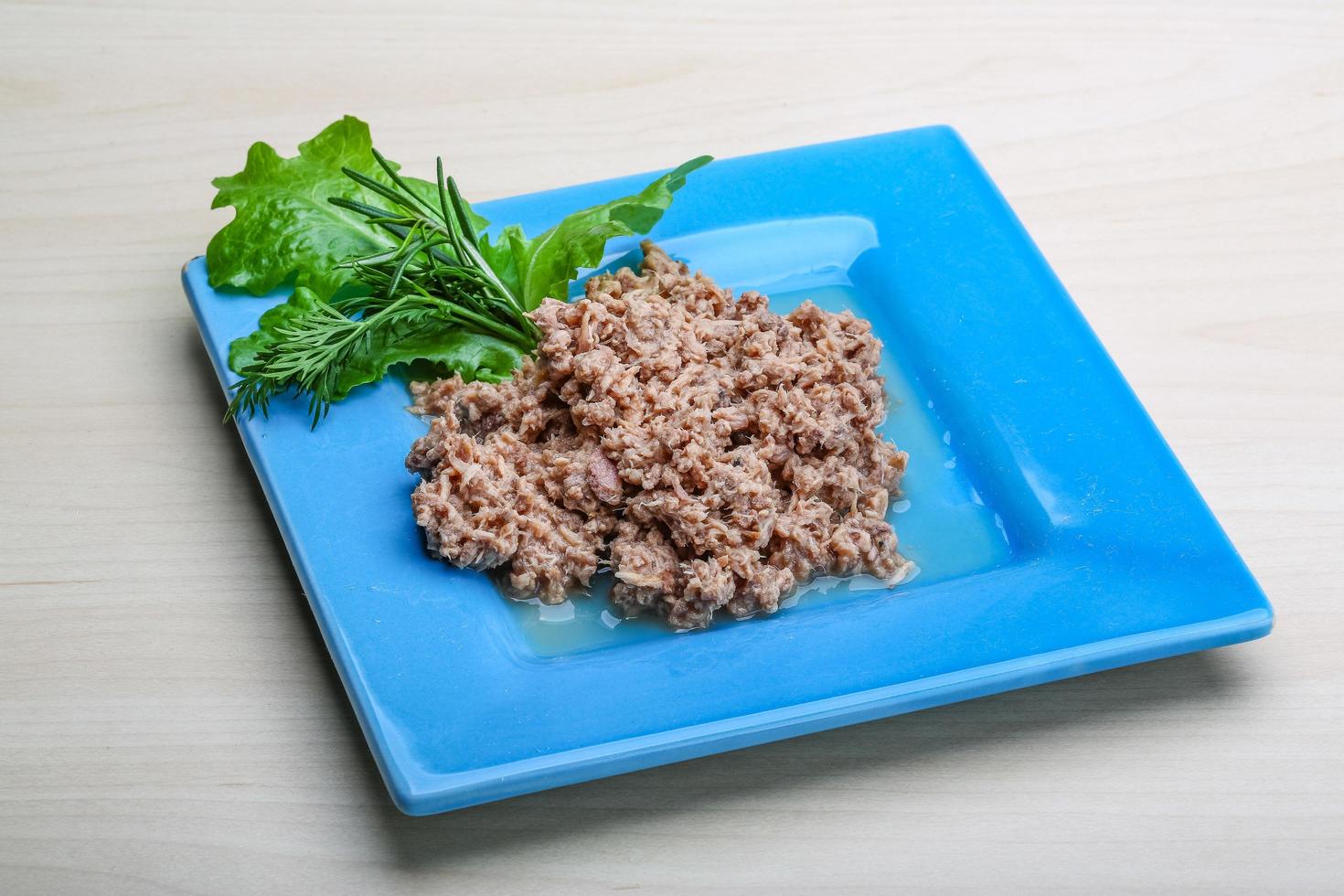 Cannded runa on the plate and wooden background photo