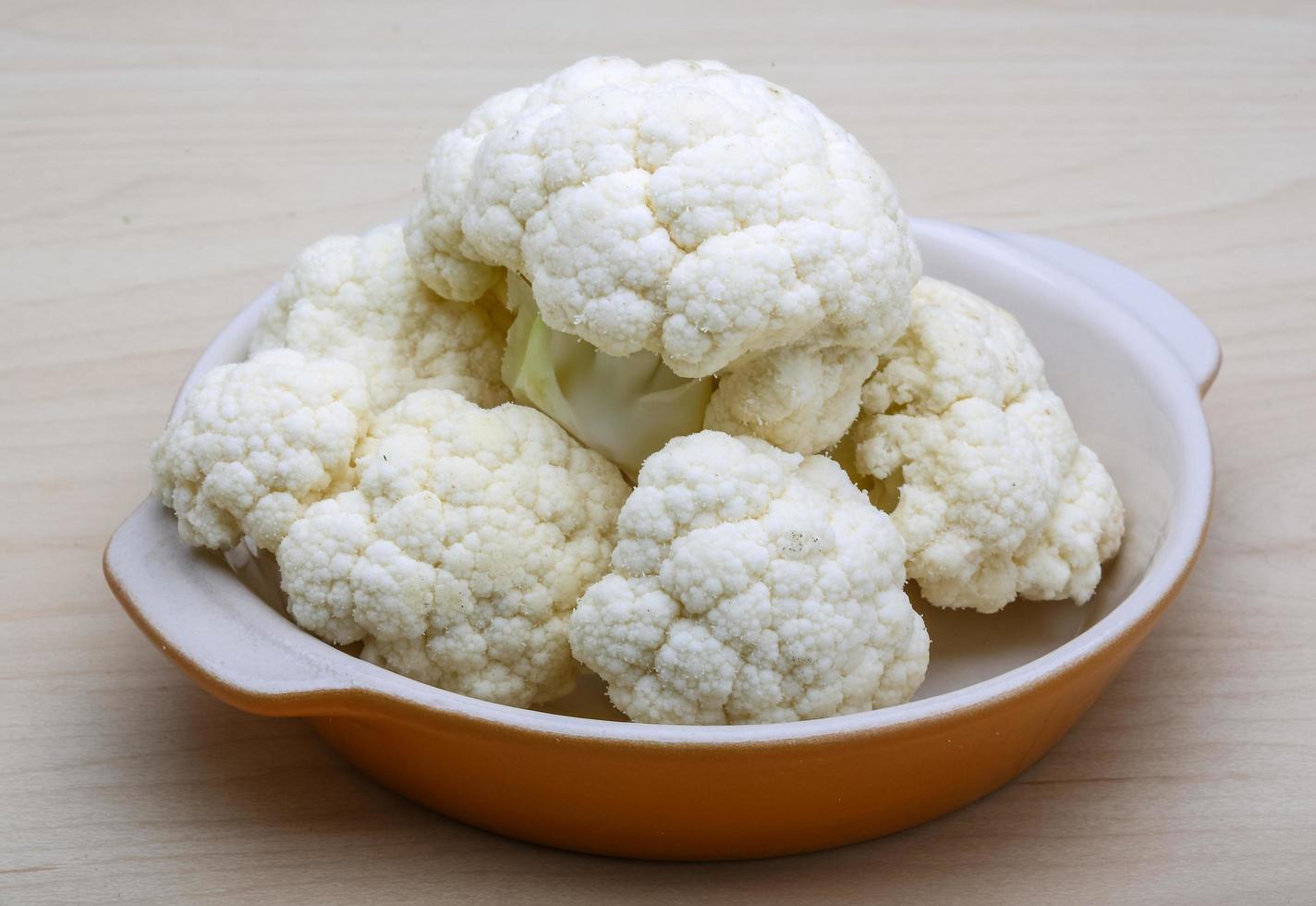 Cauliflower in a bowl on wooden background photo