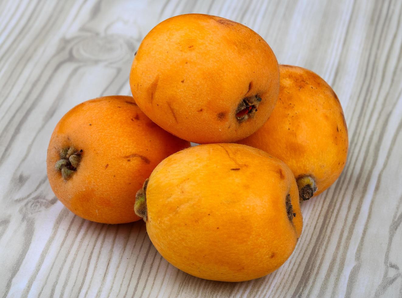 Medlar on wooden background photo