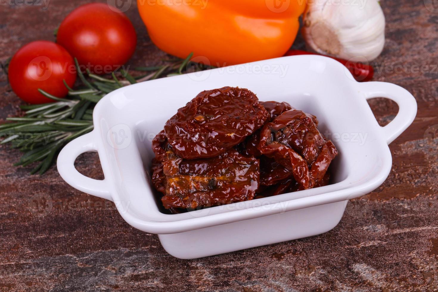 Dried tomatoes in the bowl with olive oil photo