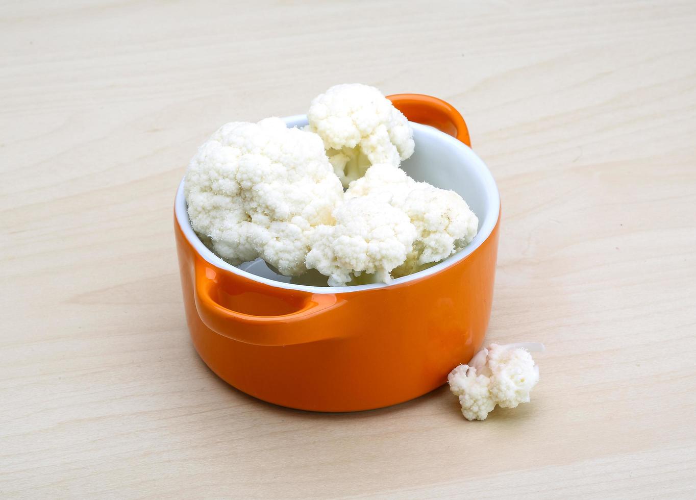 Cauliflower in a bowl on wooden background photo