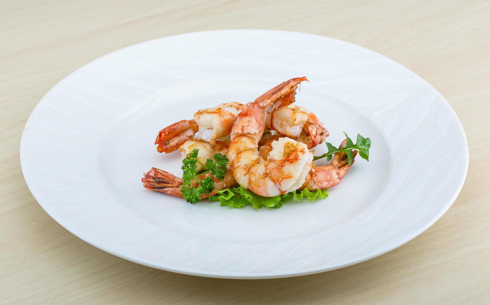 Tiger shrimps on the plate and wooden background photo