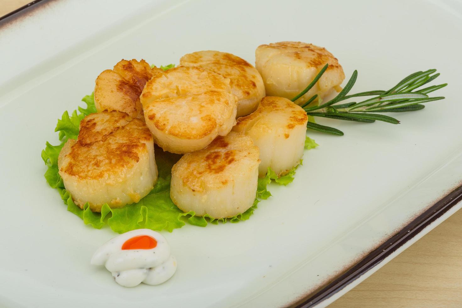 Grilled scallops on the plate and wooden background photo