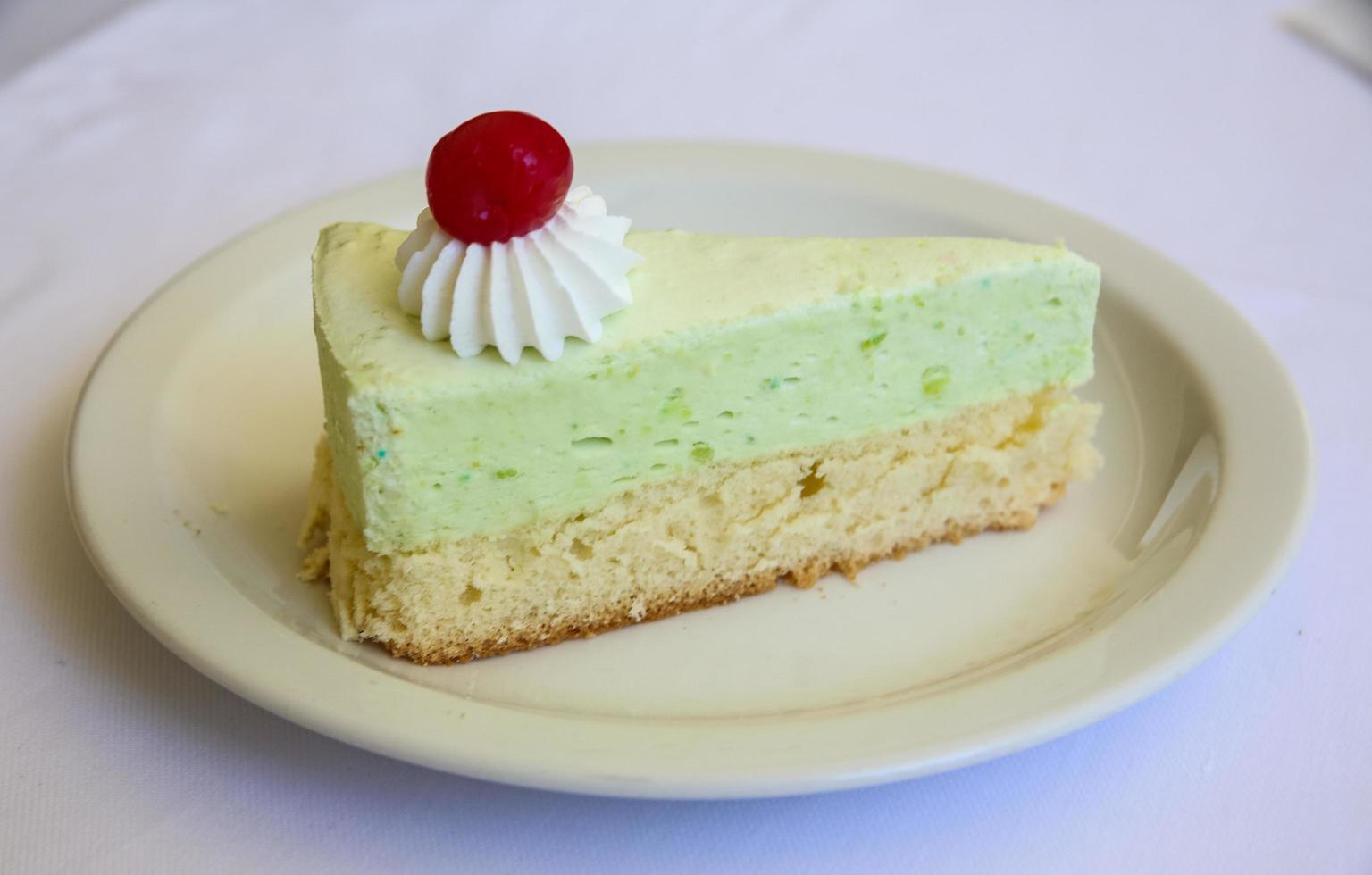 Pistachio cheesecake on the plate and white background photo