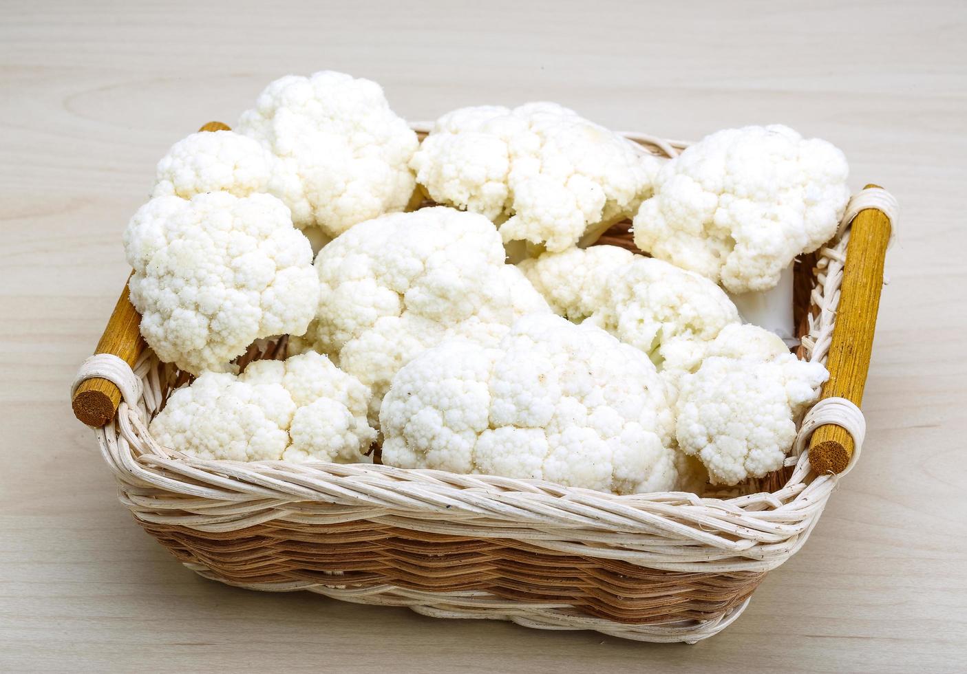 Cauliflower in a basket on wooden background photo