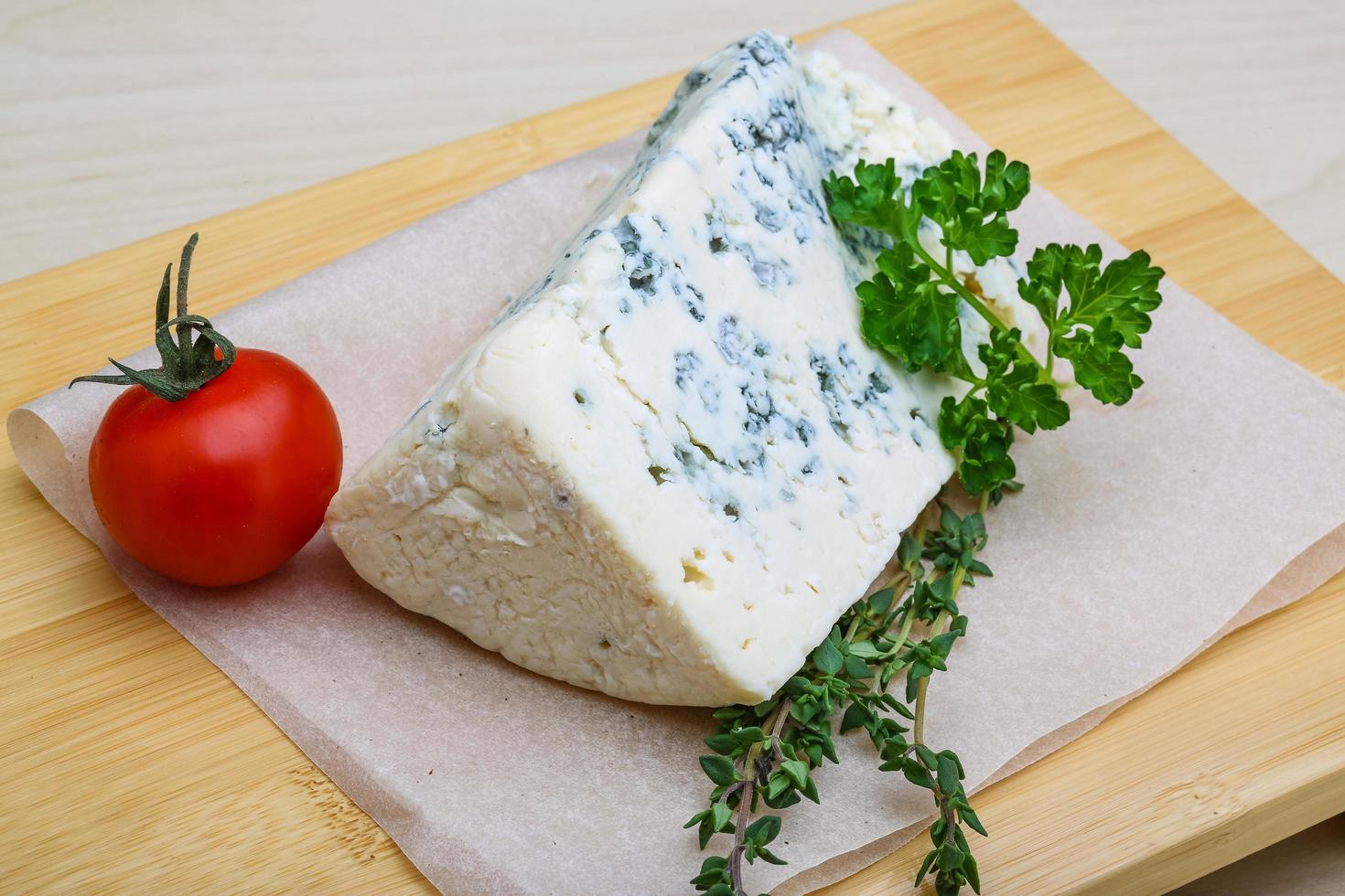 Blue cheese on wooden board and wooden background photo