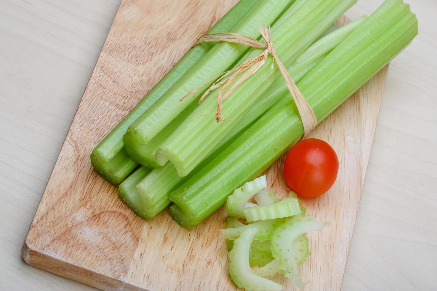 Celery on wooden board and wooden background photo