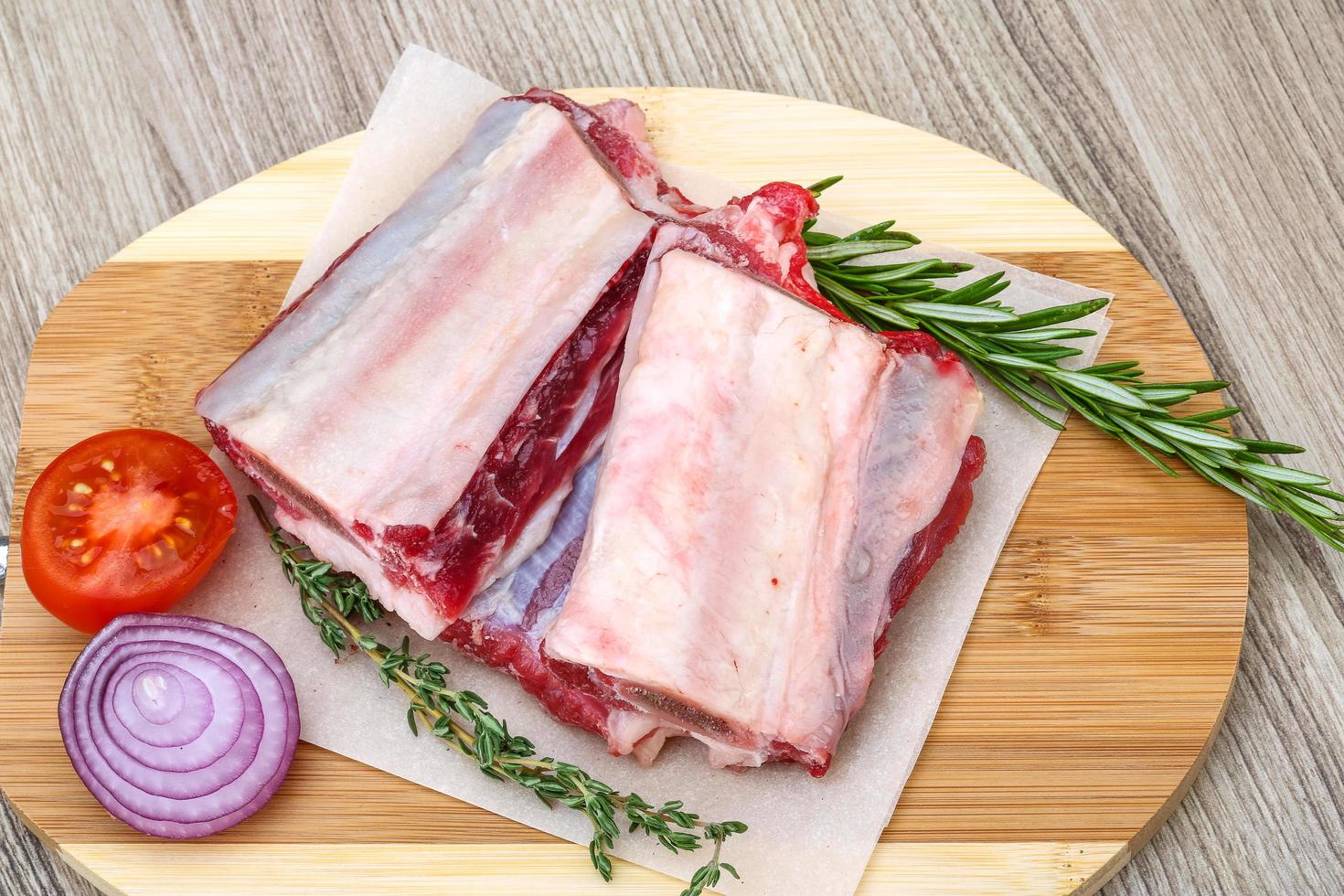 Beef ribs on wooden board and wooden background photo