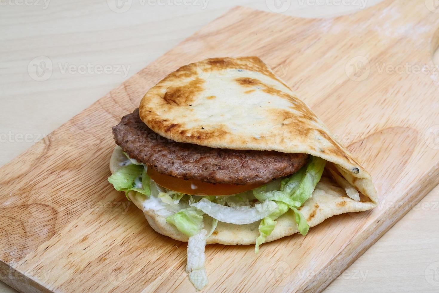 Greek pita on wooden board and wooden background photo