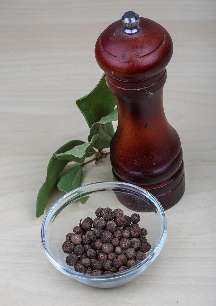 Pepper mill on wooden background photo