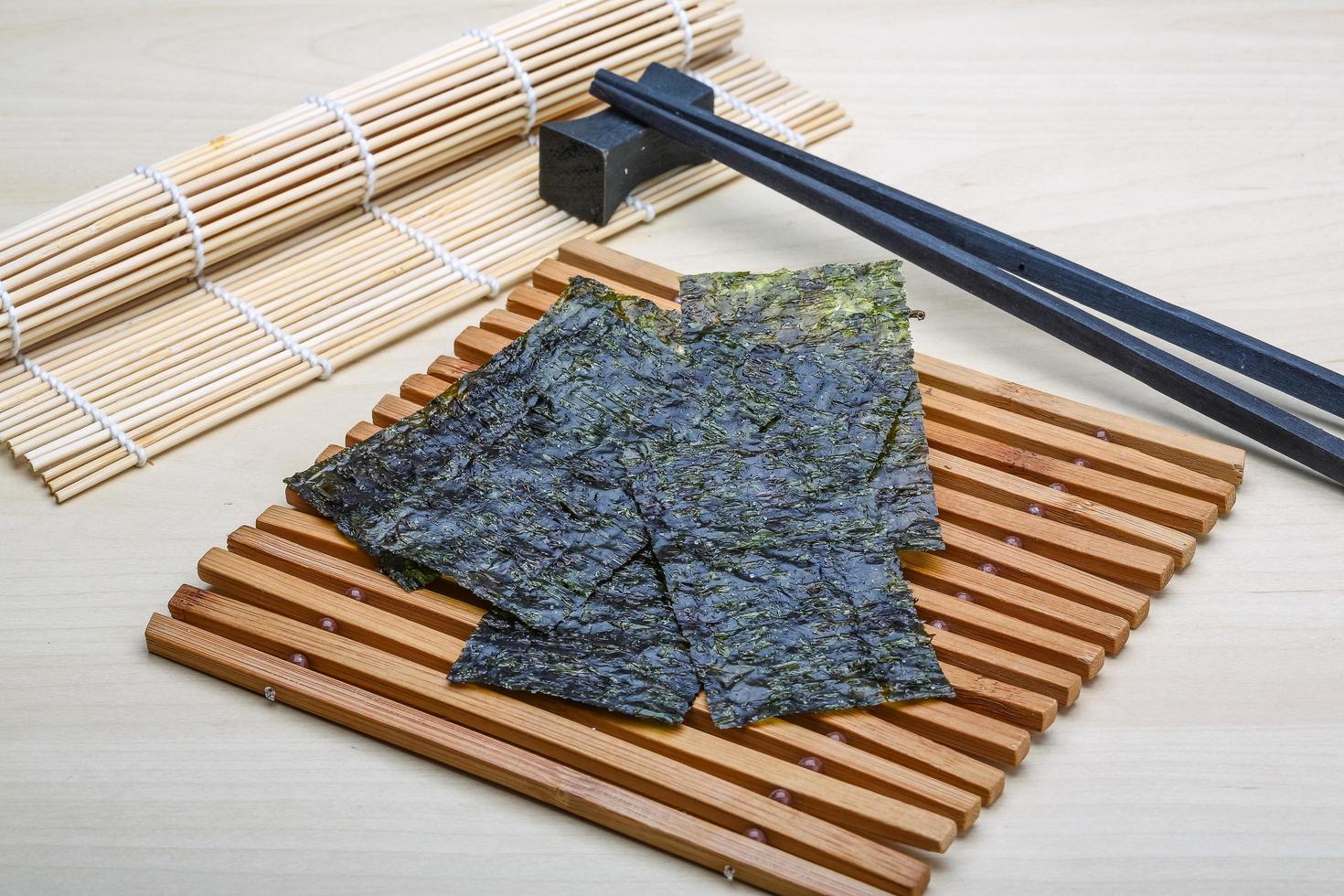 Nori sheets on wooden board and wooden background photo