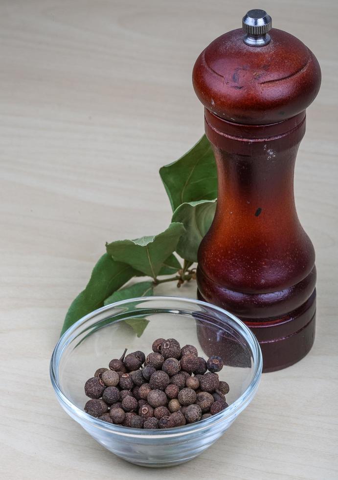 Pepper mill on wooden background photo