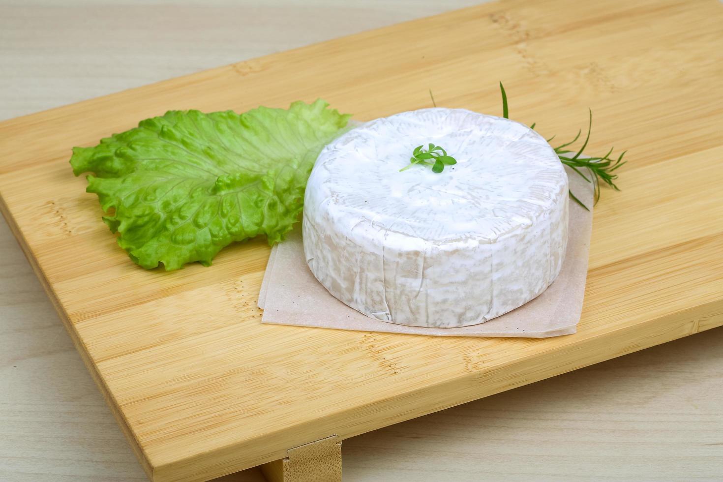 Camembert cheese on wooden board and wooden background photo