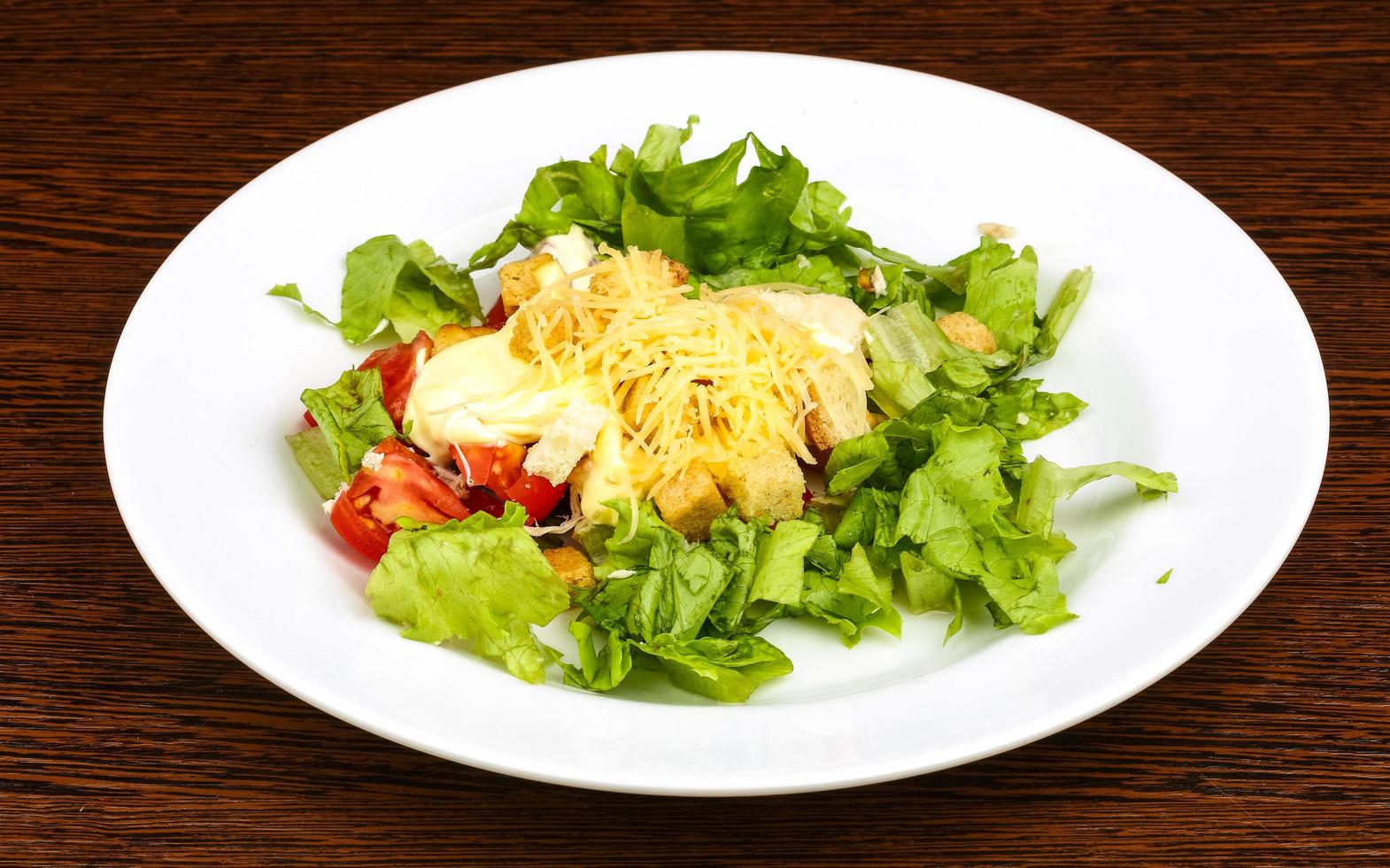 Caesar salad on the plate and wooden background photo