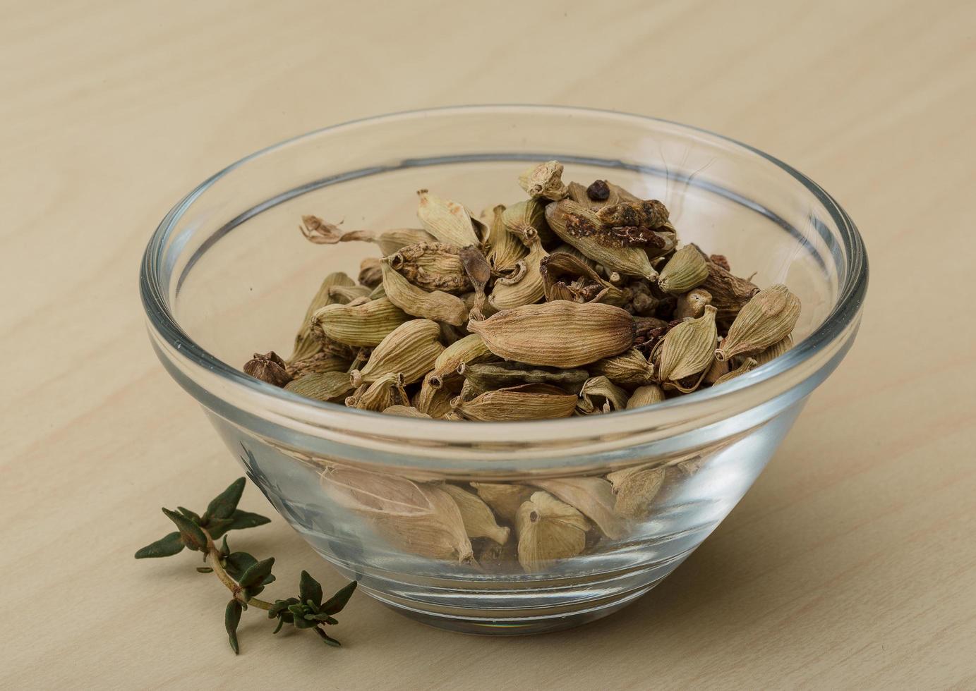 Cardamom in a bowl on wooden background photo