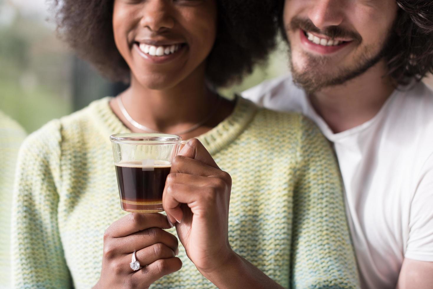 feliz pareja multiétnica relajándose en casa moderna en el interior foto