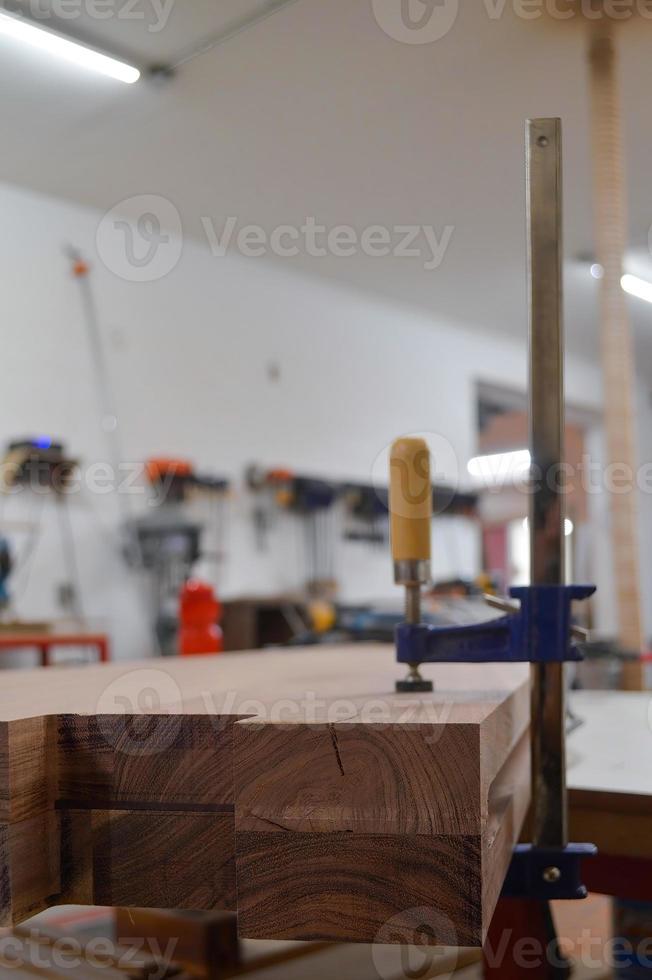 A man cuts wood on a circular saw in a joinery, band saw, holding a plank photo