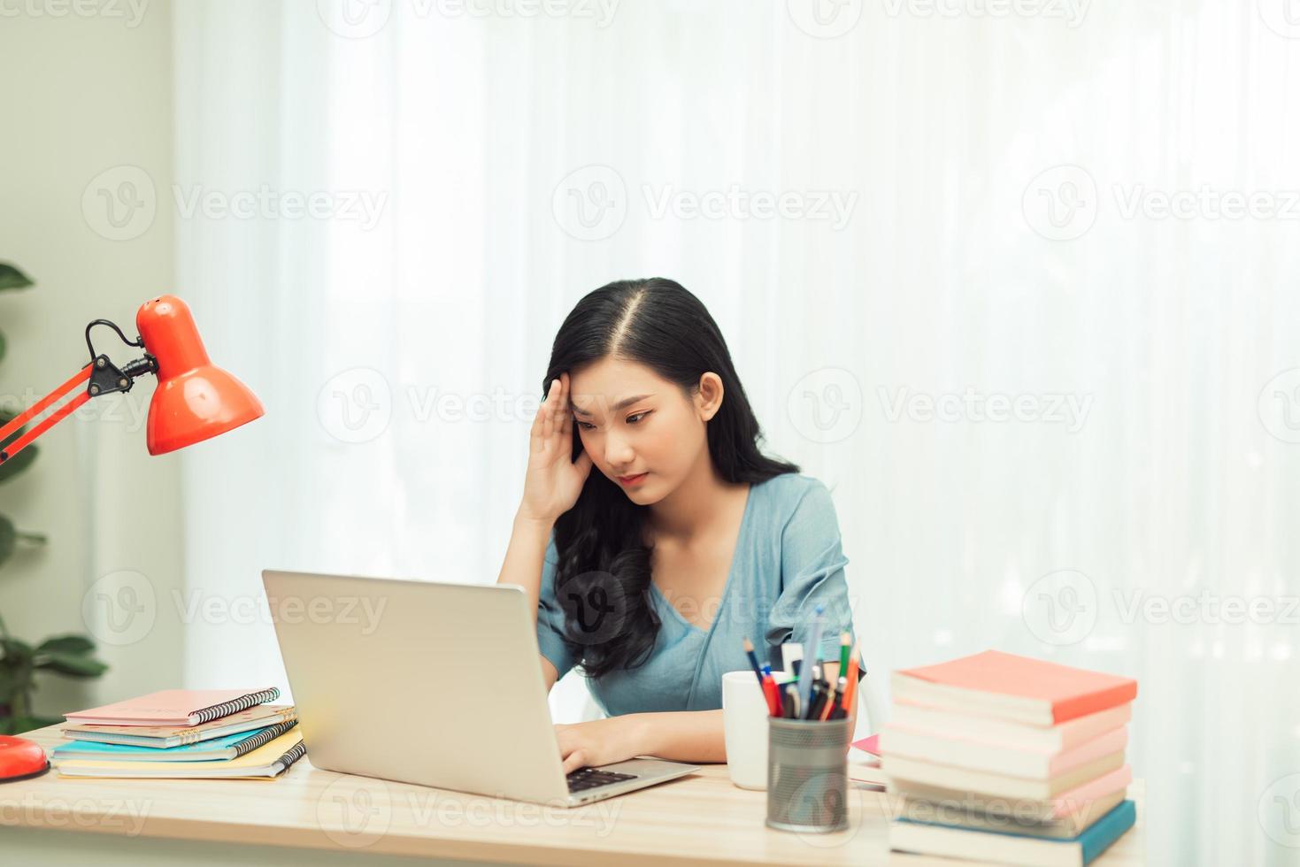 estudiante universitario estresado cansado de aprender duro con libros y portátiles en la preparación de exámenes, foto