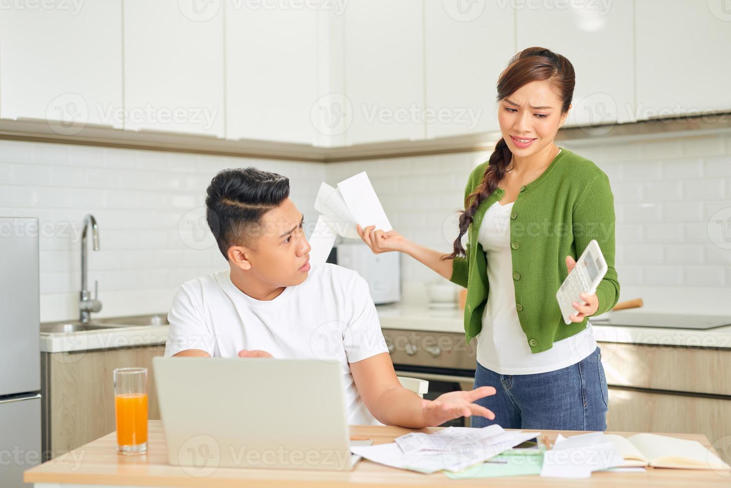 Desperate young couple with many debts reviewing their bills. Financial family problems concept. photo