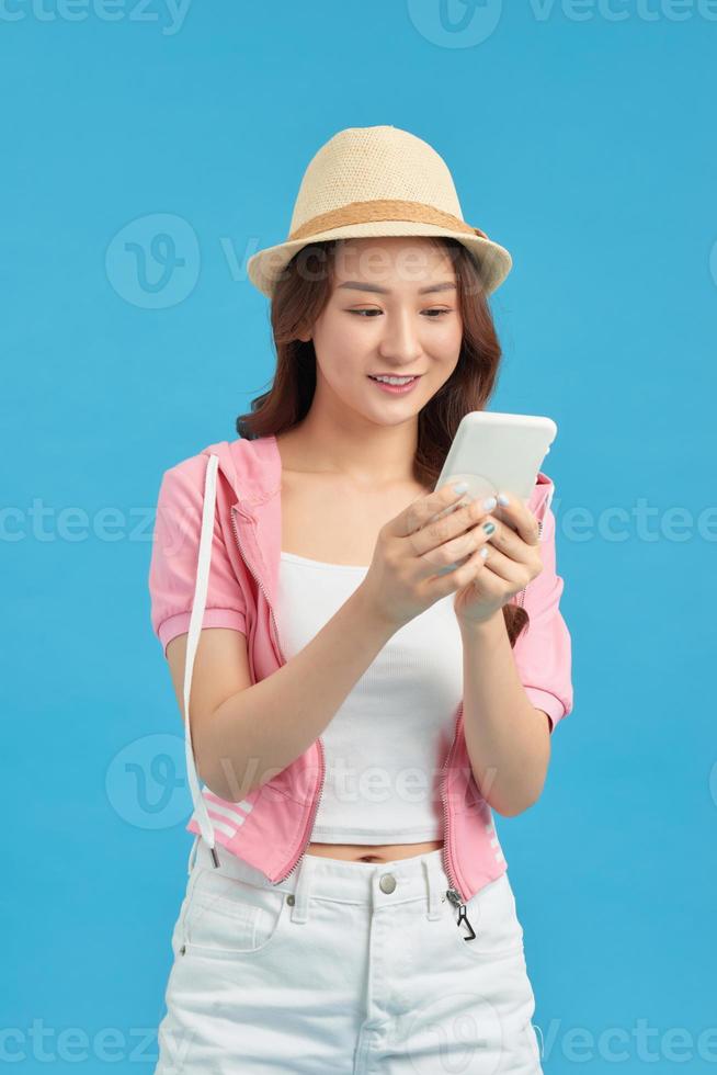 Attractive girl having smart phone in hands, checking email, using 5G internet, typing sms photo