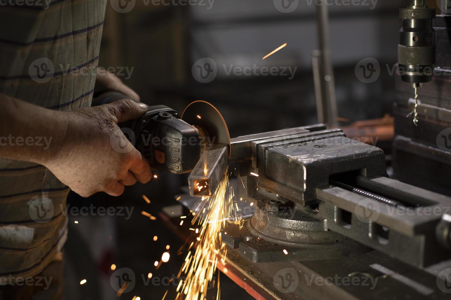 tratamiento de metales rectificado de acero. chispas del disco. trabajo en taller. foto