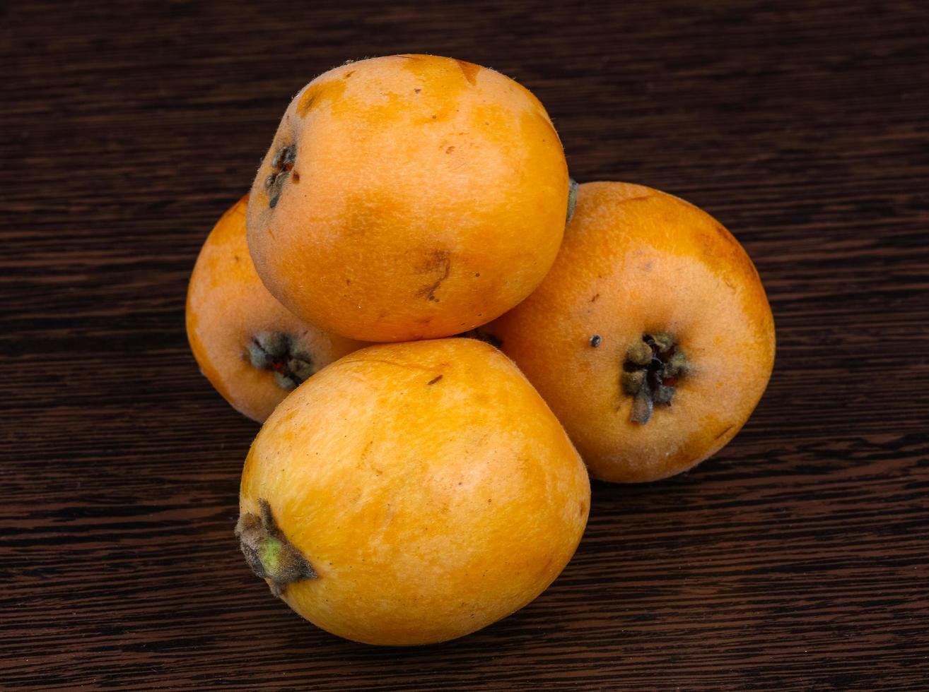 Medlar on wooden background photo