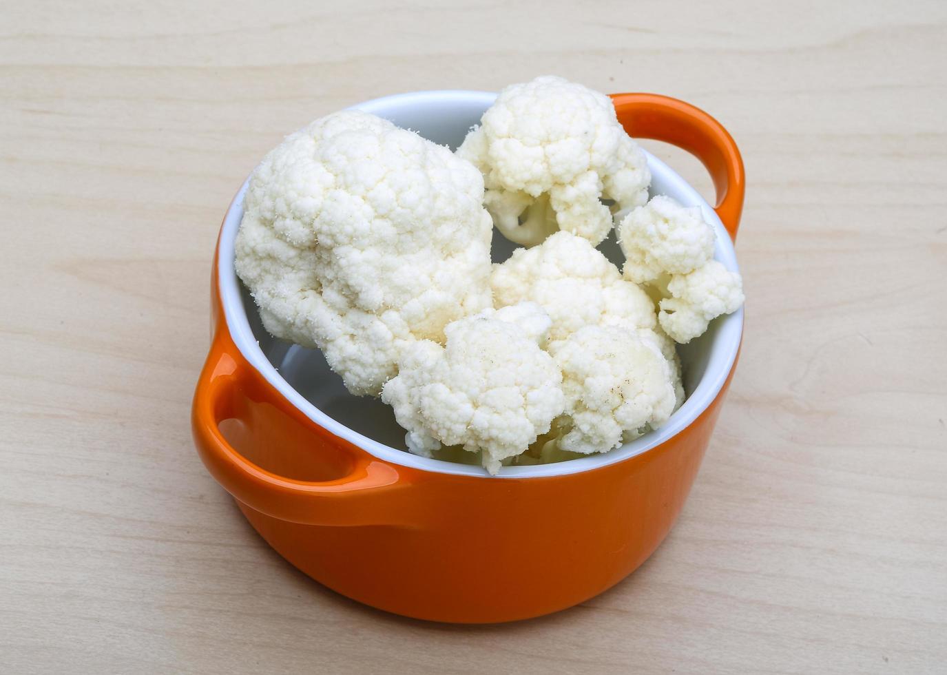 Cauliflower in a bowl on wooden background photo