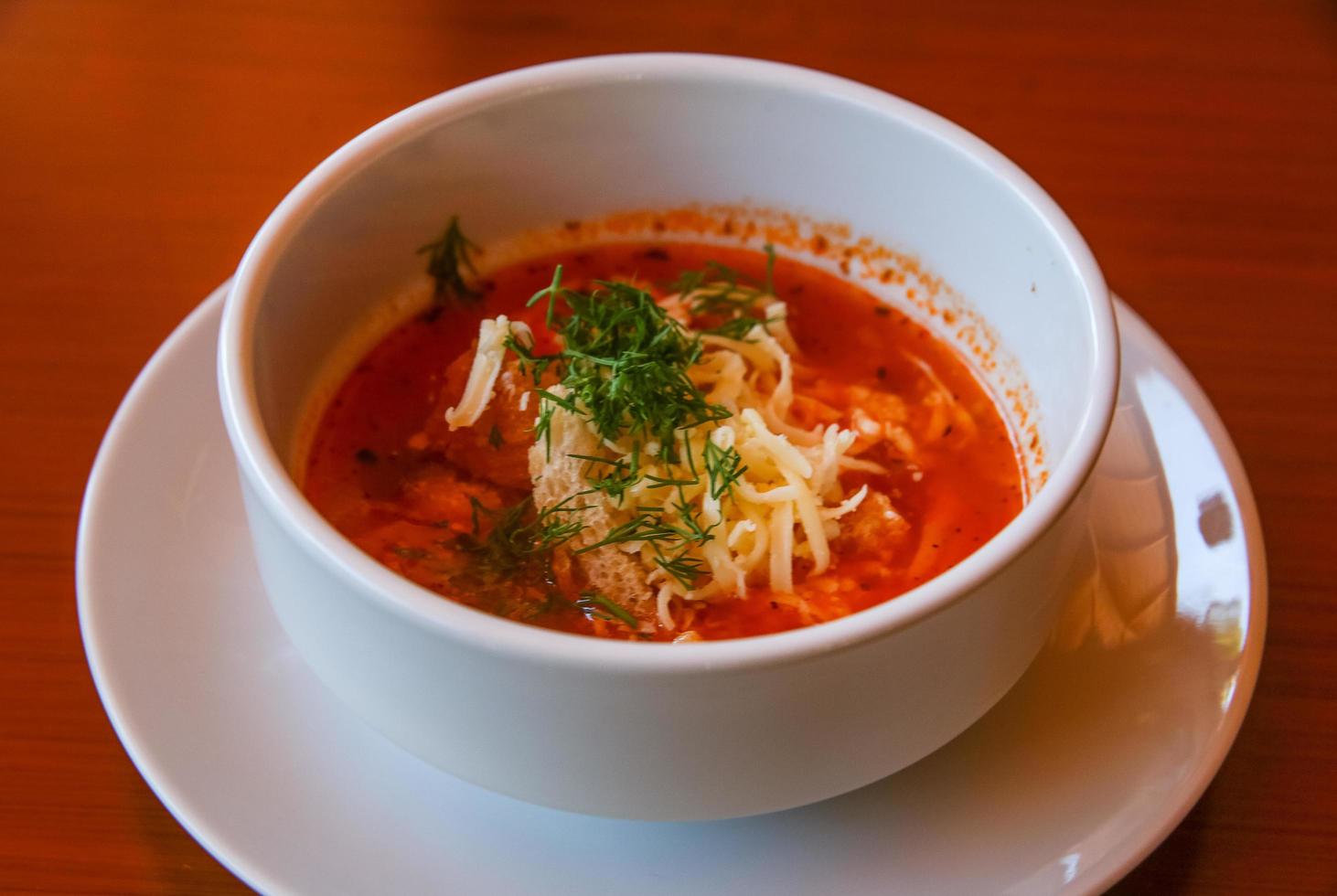 Tomato soup on wooden background photo