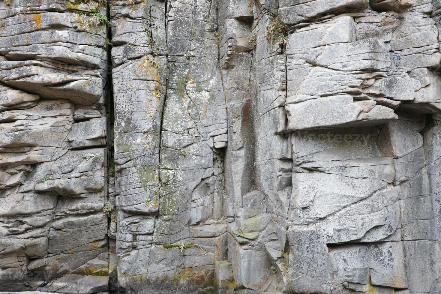 Light coarse natural rock stone background. Mining cliff rough front surface. Big limestone stack backdrop. Heavy grunge damaged granite block texture photo