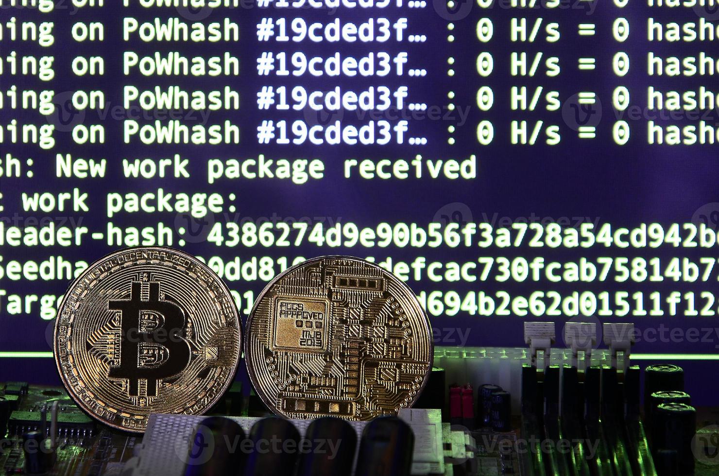 Two bitcoins lies on a videocard surface with background of screen display of cryptocurrency mining by using the GPUs photo