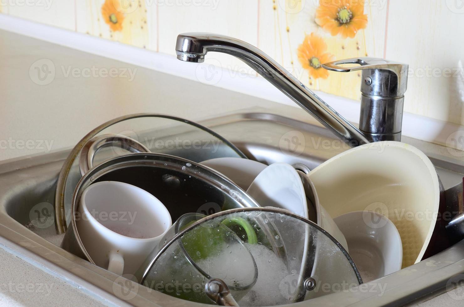 Dirty dishes and unwashed kitchen appliances filled the kitchen sink photo