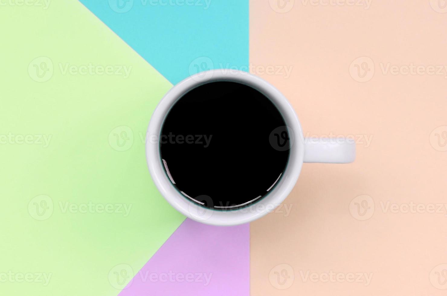 Small white coffee cup on texture background of fashion pastel pink, blue, coral and lime colors paper photo