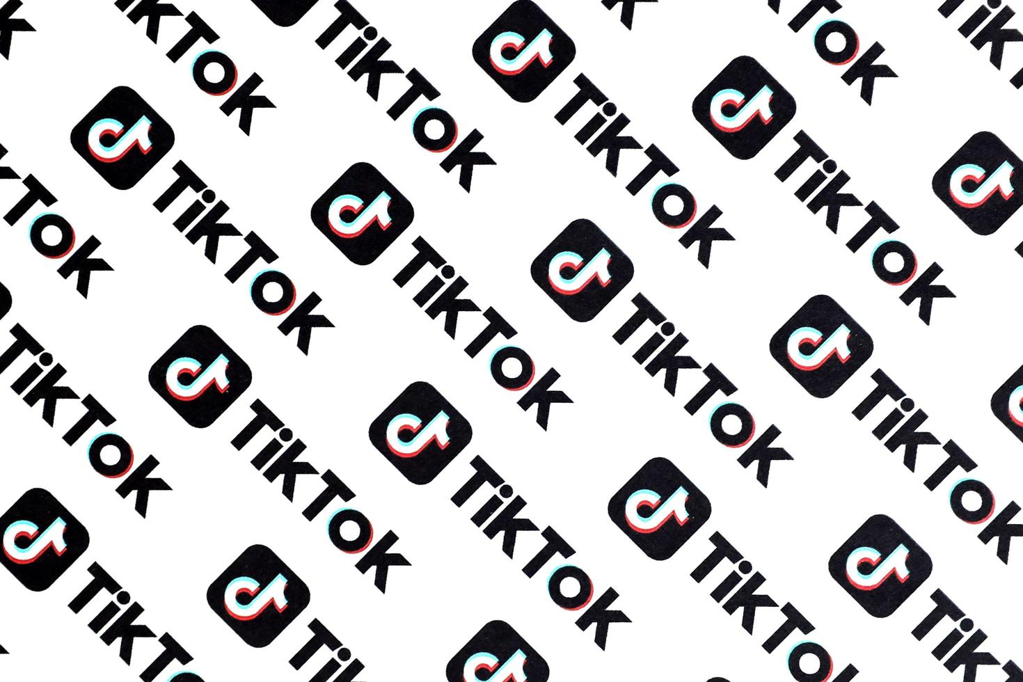 TERNOPIL, UKRAINE - MAY 2, 2022 Many TikTok logo printed on paper. Tiktok or Douyin is a famous Chinese short-form video hosting service owned by ByteDance photo