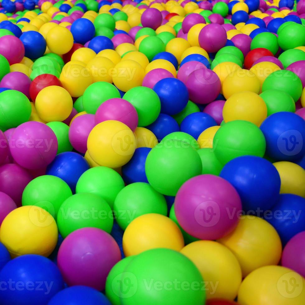 Many colorful plastic balls in a kids' ballpit at a playground. Close up pattern photo