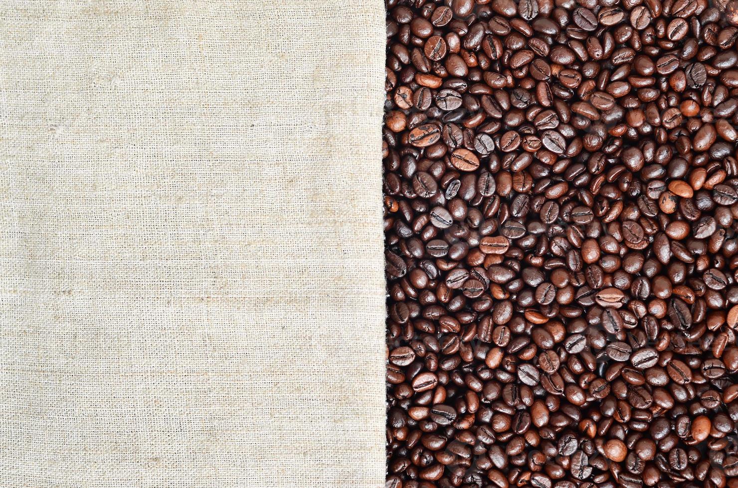 Texture of a gray canvas made of old and coarse burlap with coffee beans on it photo