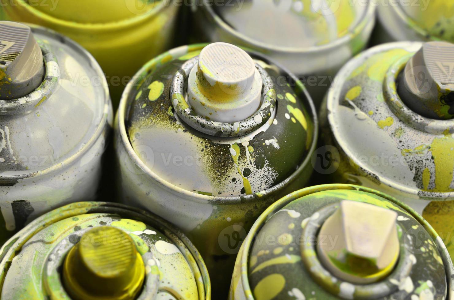 A lot of used spray cans of paint close-up. Dirty and smeared cans for drawing graffiti. The concept of a sweeping and careless drawing of paint. Creative art image photo