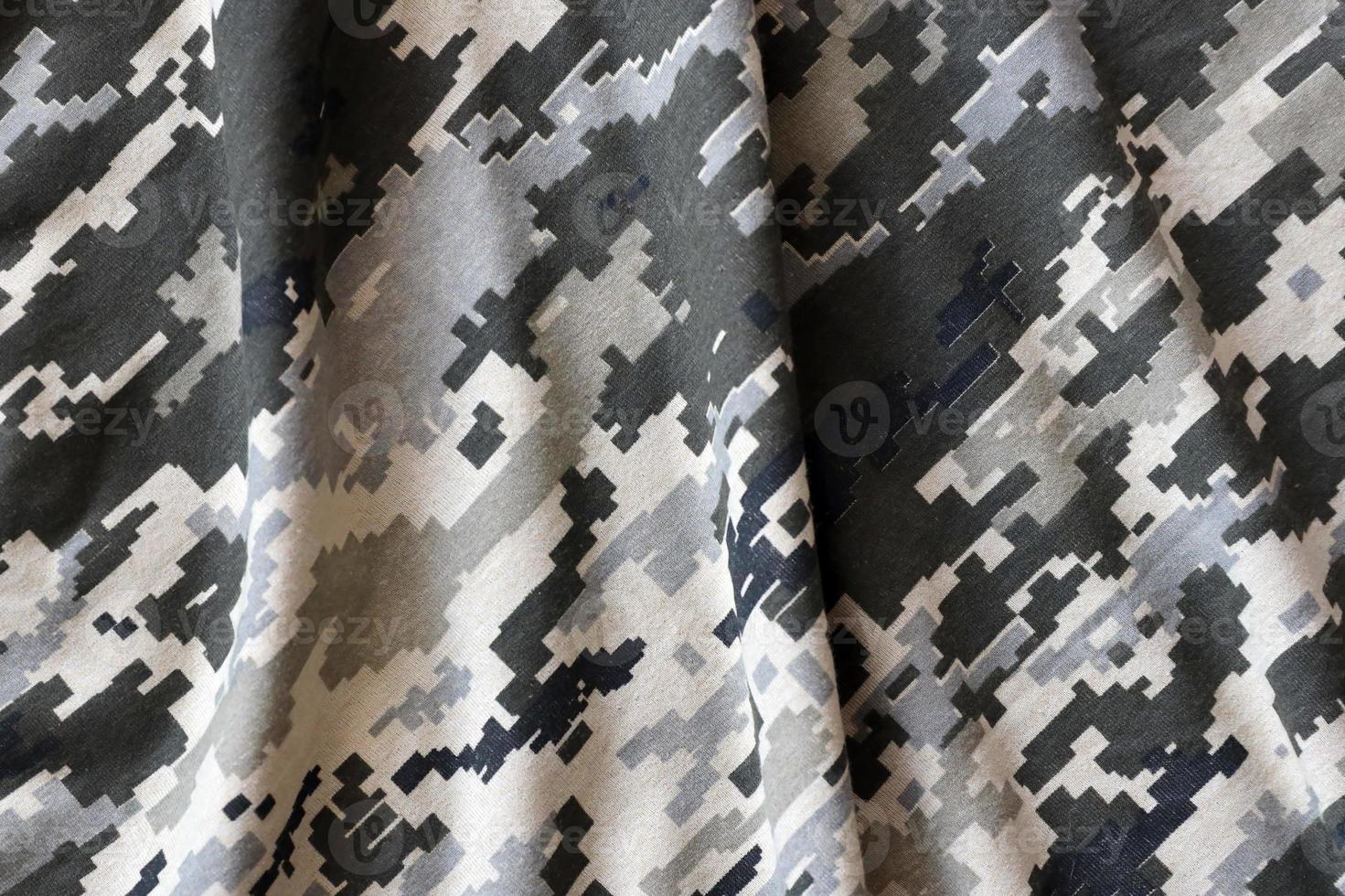Fabric with texture of Ukrainian military pixeled camouflage. Cloth with camo pattern in grey, brown and green pixel shapes. Official uniform of Ukrainian soldiers photo