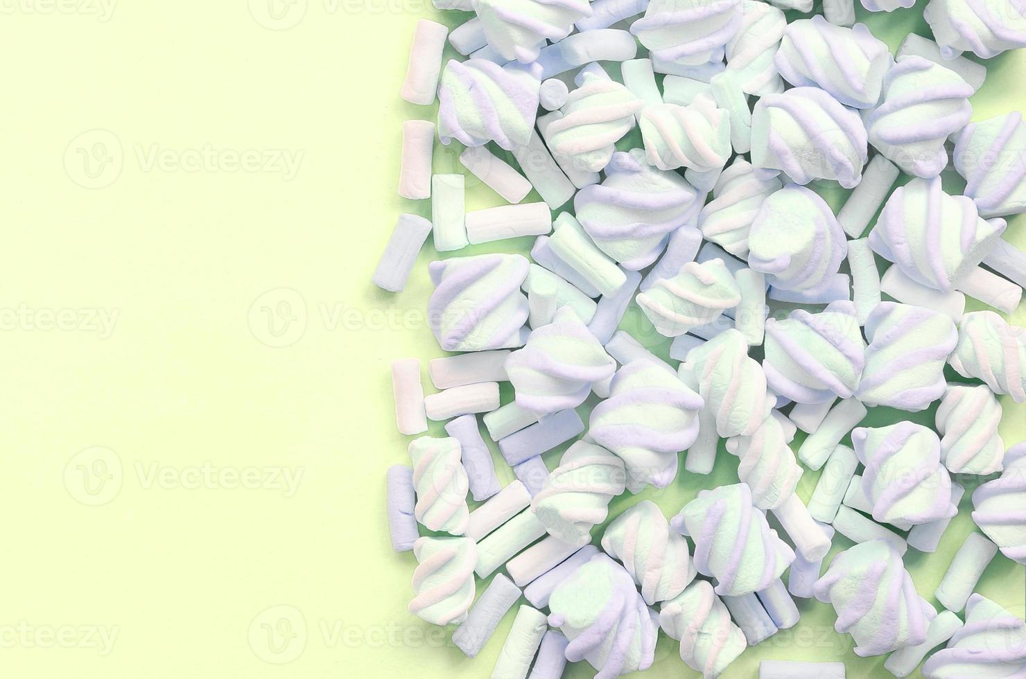 Colorful marshmallow laid out on lime paper background. pastel creative texture photo
