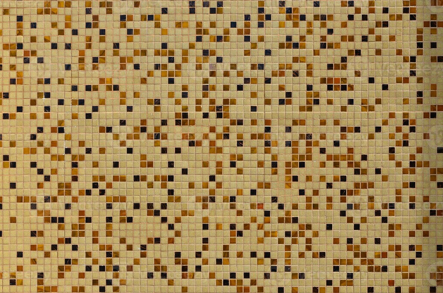 The texture of the wall, decorated with a mosaic of various small square tiles. Abstract pattern of ceramic tiles on the wall photo